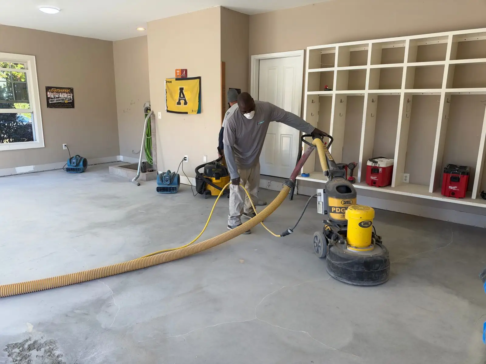Grinding a garage floor with a dust-controlled floor grinder before epoxy in Boone