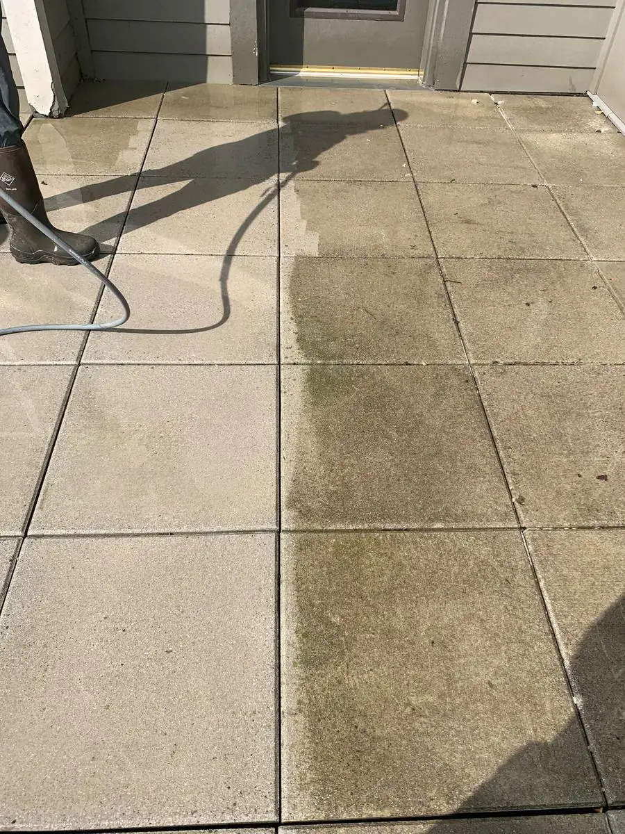 Concrete paver patio partway through pressure washing